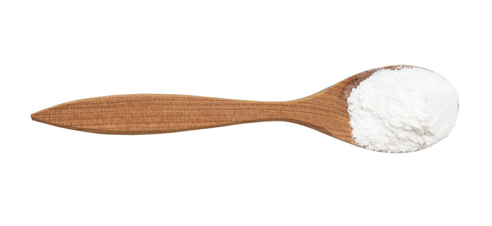 Baking powder in wood spoon.