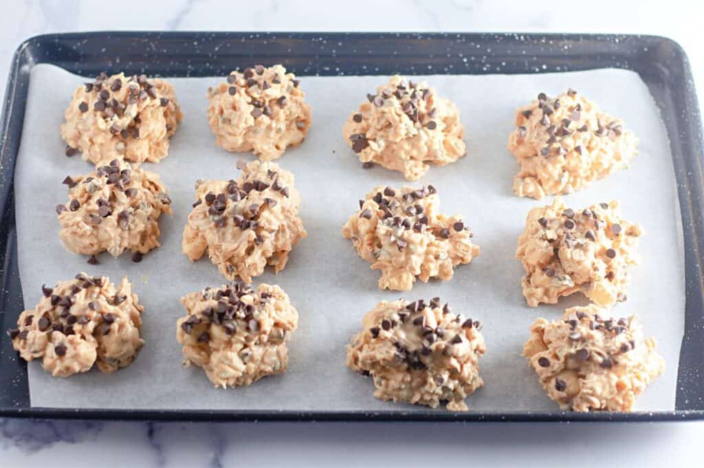 A baking sheet filled with cookies on top of a marble counter.