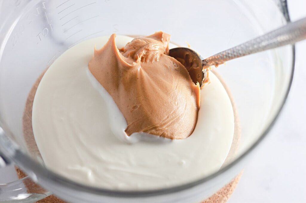 A blender with cream and chocolate in it.