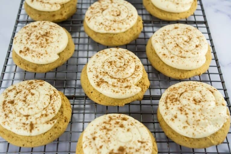 Close-up of frosted pumpkin cookies with cream cheese caramel frosting and spice.