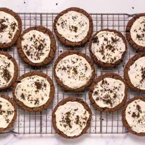 Delicious chocolate cookie cups topped with creamy frosting and chocolate sprinkles, perfect for baking lovers.
