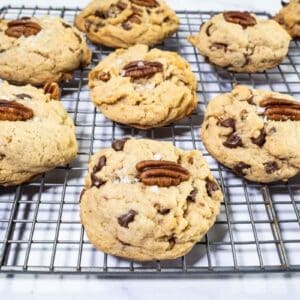 Browned butter bourbon pecan chocolate chip cookies on a wire rack.