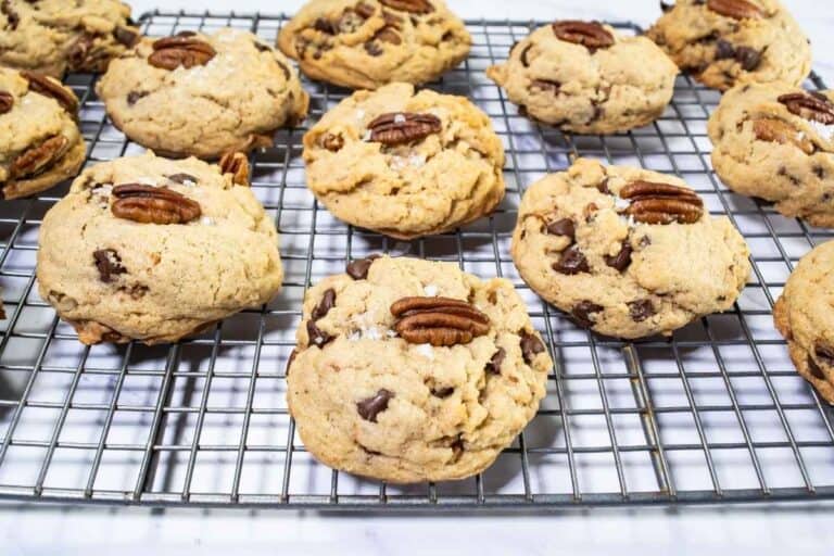Browned butter bourbon pecan chocolate chip cookies on a wire rack.