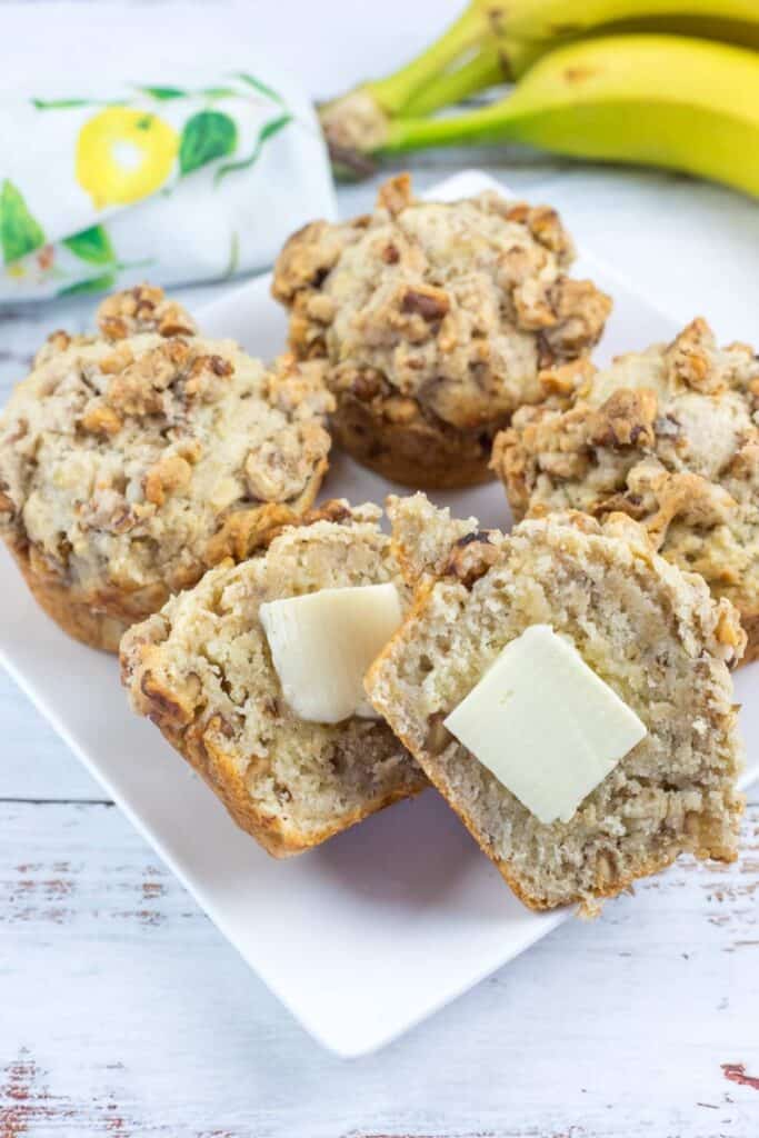 A white plate with a Banana Nut Muffins with Nutty Crumble Topping.