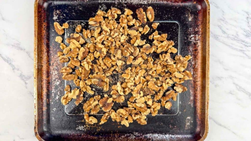 Spread the walnuts on a baking sheet and toast them.